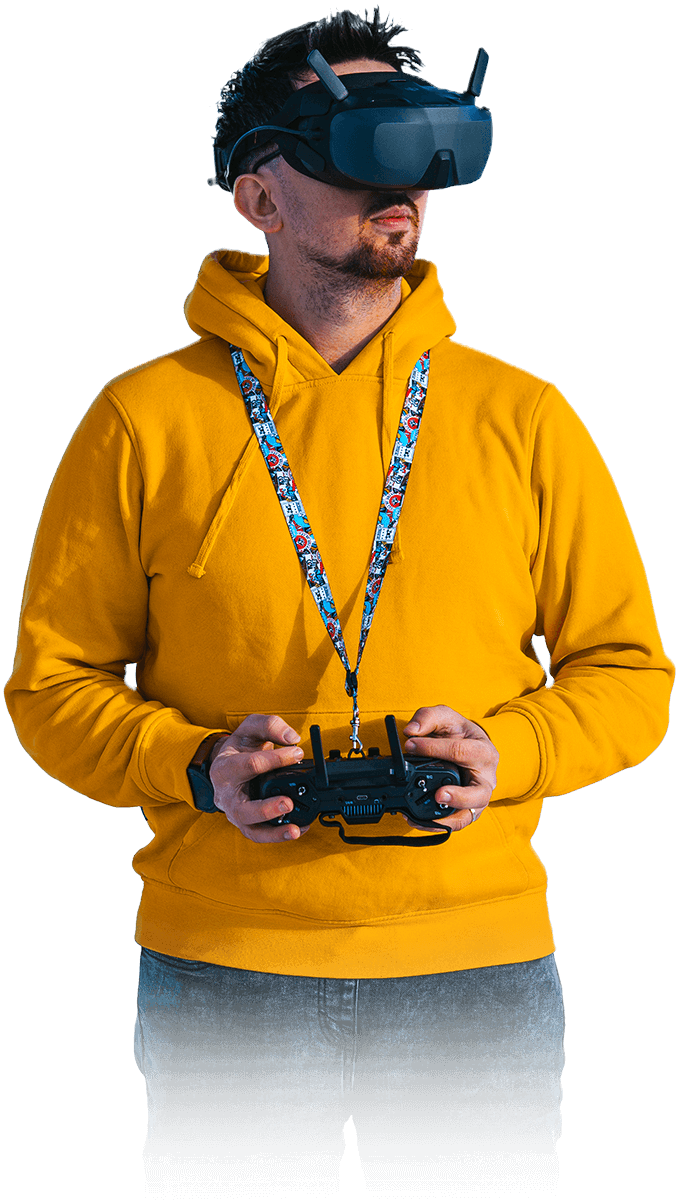 Mężczyzna w okularach FPV w żółtej bluze z padem do sterowania dronem